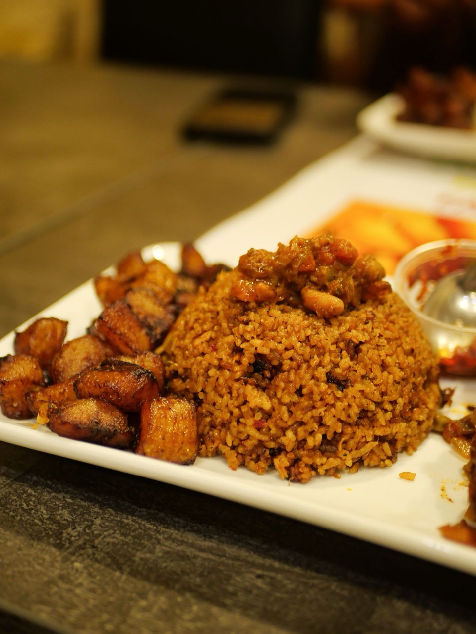 A Dominican plate — yellow rice with stewed meat and sweet fried plantains
