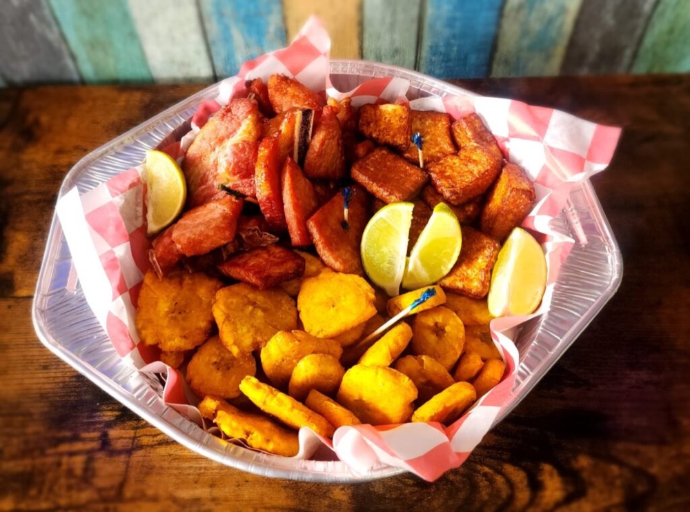Basket of fried pork, fried cheese and tostones with lime